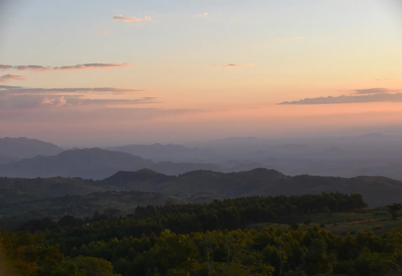 Successive wooded ridgelines fading into layers of haze at dusk