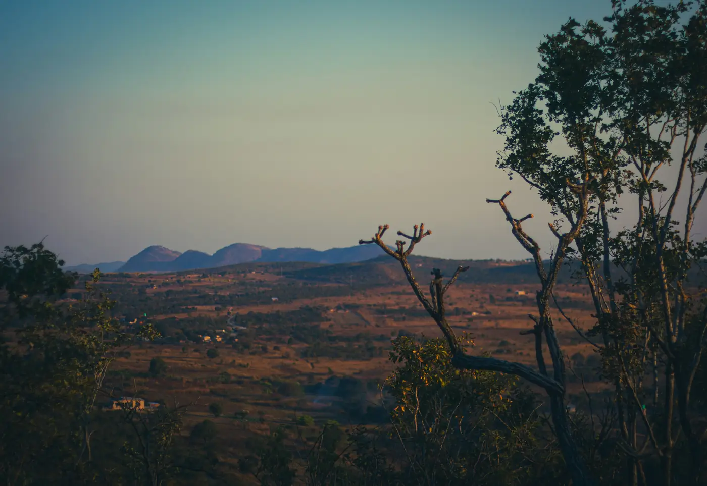 Dry-season Zambian plateau landscape with low hazy hills on the horizon
